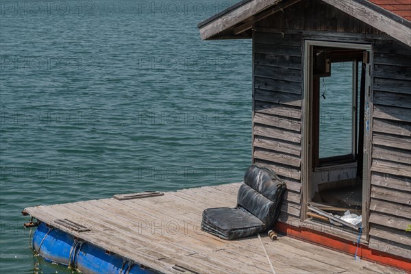 Old abandoned fishing shack and dock floating on surface of lake