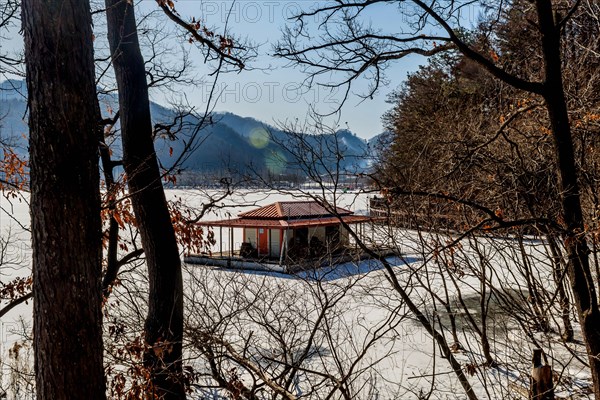 Goesan-gun, South Korea, Jan. 20, 2021: Winter landscape of fishing hut docked on frozen snow covered lake, Asia