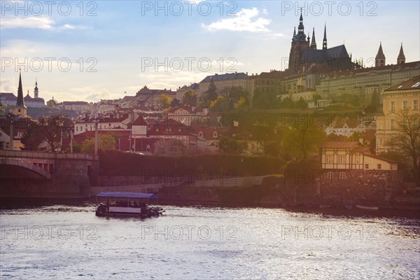 Boats on Vltava river and Hradcany castle in the background, in Prague, Czech Republic (Czechia), at sunset