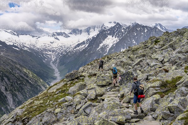 Mountaineer on hiking trail, view of glaciated rocky mountain peaks Hoher Weisszint and Hochfeiler with glacier Schlegeiskees, Berliner Hoehenweg, Zillertal Alps, Tyrol, Austria, Europe