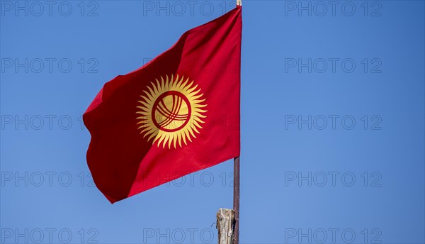 Kyrgyz national flag in front of a blue sky, Kyrgyzstan, Asia