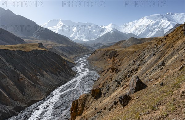 Achik Tash river, Achik Tash valley with rock formations, behind glaciated and snow-covered mountain peak Pik Lenin and Pik of the XIX Party Congress of the CPSU, Trans Alay Mountains, Pamir Mountains, Osh Province, Kyrgyzstan, Asia