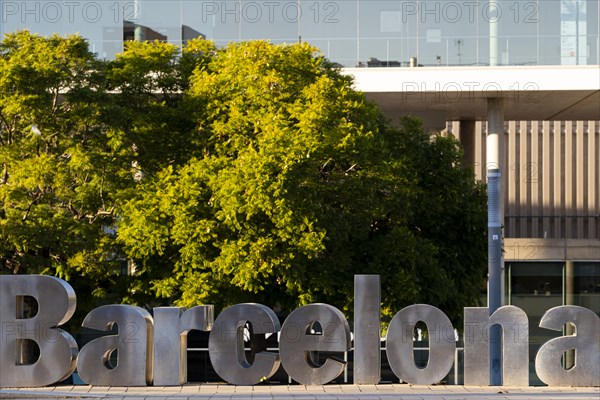 Sign of large aluminum letters with the word Barcelona in a modern city square