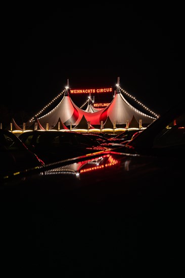 Tents of the 'Christmas Circus' with fairy lights mirrored on cars, Reutlingen, Germany, Europe