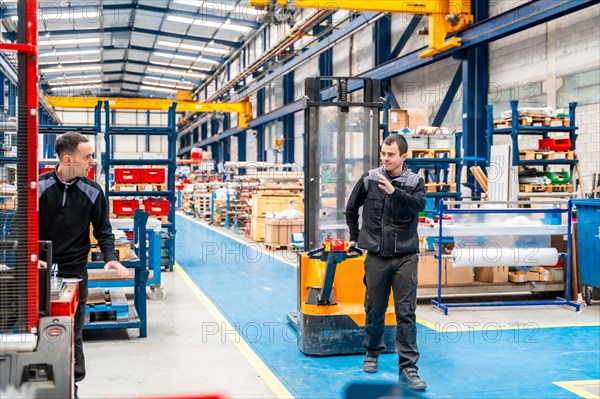 Coworkers taking while using handcart in a logistic center