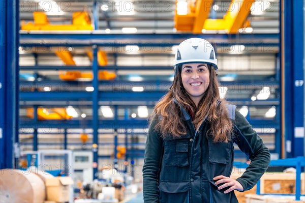 Portrait of a smiling female worker with protective gear standing in a logistic center