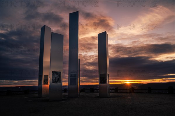 Modern sculptures in front of a dramatic sunset sky with reflections, World War II memorial, Pforzheim, Germany, Europe