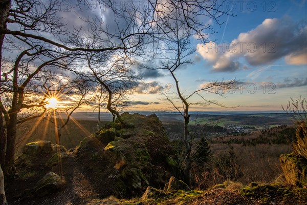 Landscape at the Grosser Zacken, Taunus volcanic region. A cloudy, sunny autumn day, meadows, hills, fields and forests with a view of the sunset. Hesse, Germany, Europe