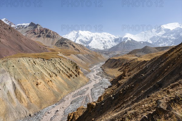 Achik Tash river, Achik Tash valley with rock formations, behind glaciated and snow-covered mountain peak Pik Lenin and Pik of the XIX Party Congress of the CPSU, Trans Alay Mountains, Pamir Mountains, Osh Province, Kyrgyzstan, Asia