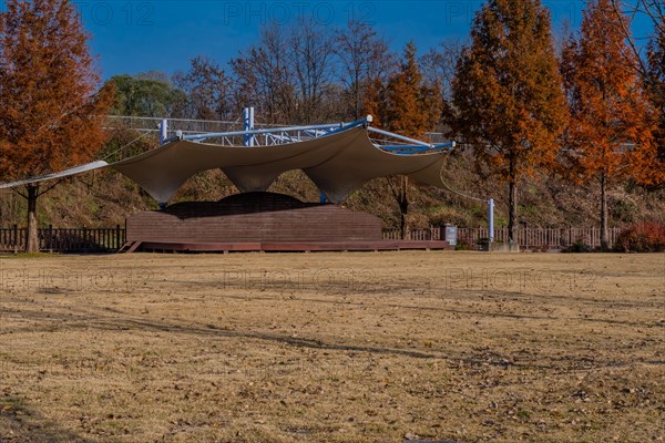 Outdoor event and performance stage with white canvas awning located in public park