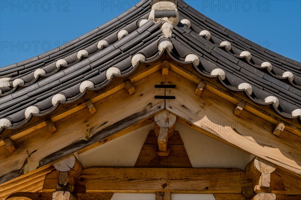 Closeup low angle view of ceramic tiled roof on oriental gate at public park