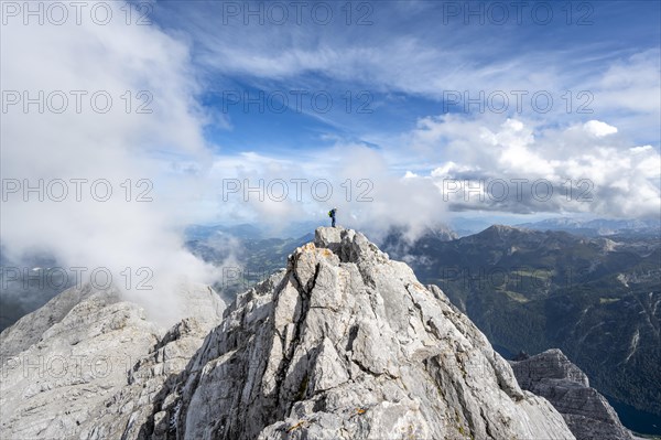 Mountaineer on the rocky summit of the Watzmann Mittelspitze, Watzmann crossing, view of mountain panorama, Berchtesgaden National Park, Berchtesgaden Alps, Bavaria, Germany, Europe