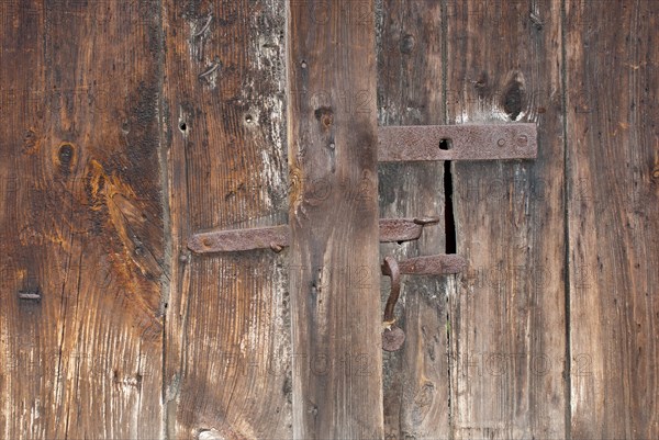 Close-up of an old wooden door with rusty, iron bolt and visible wood grain, weathering, symbol of nostalgia, decay, vacancy, need for renovation, ageing, background, Mecklenburg-Western Pomerania, Germany, Europe