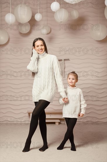 Happy loving family at home. Mother and her daughter in similar styled clothes