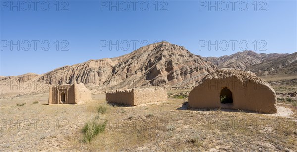 Clay mausoleums, tombs, old Kyrgyz cemetery, between dry eroded landscape, Naryn region, Kyrgyzstan, Asia