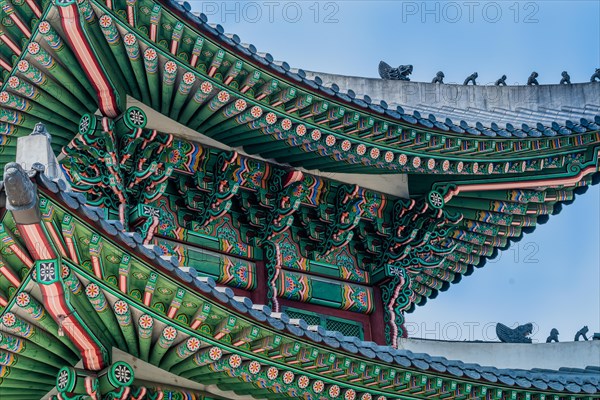 Seoul, South Korea, March 18, 2017:Tiled roof of Seoul's Gyeong Bok Gung Palace in stunning colors with small figurines on the eves set against a blue sky in the background, Asia