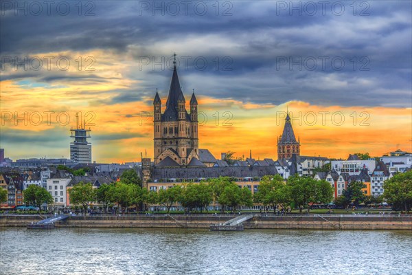 View of a church and town on the riverbank at sunset with dramatic sky, Hohenzollern Bridge, Cologne Deutz, North Rhine-Westphalia, Germany, Europe
