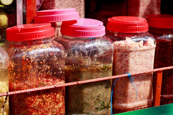 Rows of assorted authentic traditional khmer crack sauces called Chrouk Metae or chili paste, prahok or fermented fish paste and Tuk trey or fish paste sold in the local market of Kampot, Cambodia, Asia