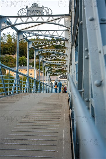 People walking across an ornate steel bridge in an urban area, Mozartsteg, Salzburg, Austria, Europe