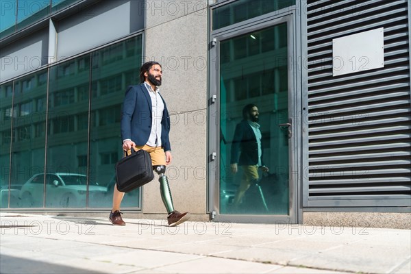 Horizontal photo with copy space of a businessman with prosthetic leg commuting walking in a financial district