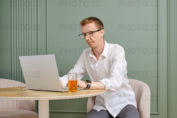 Middle aged man using laptop looking for an apartment to rent