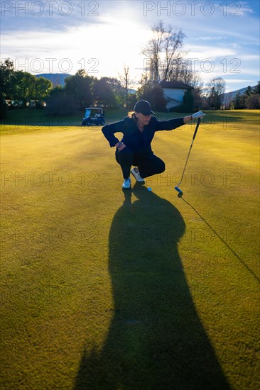 Female Golfer with Shadow on the Putting Green in Sunset with Lens Flare on Golf Course in Switzerland