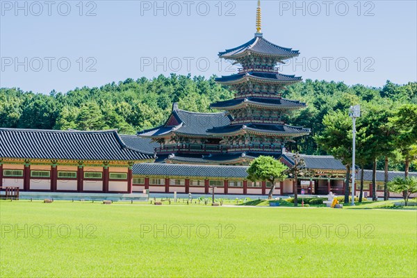 Buyeo, South Korea, July 7, 2018: Main gate of Neungsa Baekje Temple with golden spire on top of five story pagoda, Asia