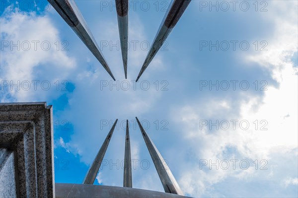 Curved, pointed spires of building reaching into beautiful partly cloudy blue sky