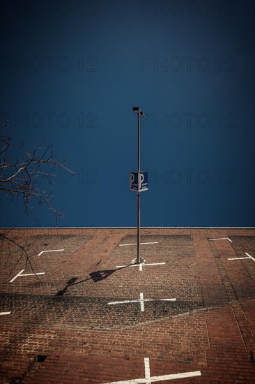 Lighting column and car park sign cast a shadow on a large brick wall, Cologne Deutz, North Rhine-Westphalia, Germany, Europe