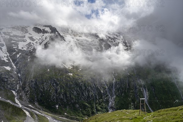 Snow-covered cloudy mountains with summit Hochsteller, mountain streams as waterfalls on a mountainside, Furtschaglhaus, Berliner Hoehenweg, Zillertal, Tyrol, Austria, Europe