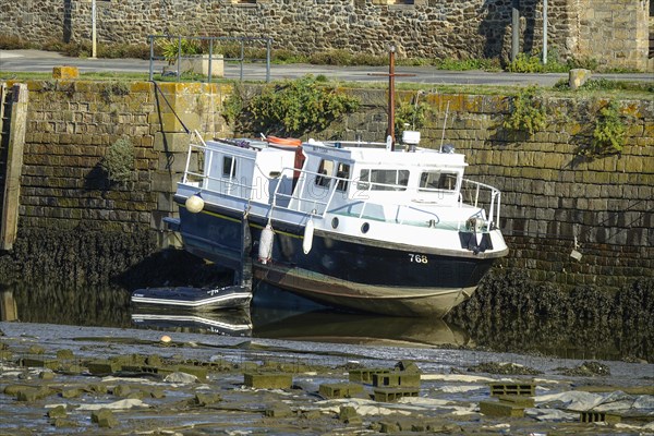 Boat lying on dry land at low tide on the Riviere du Faou on the Rade de Brest, Le Faou, Finistere department, Brittany region, France, Europe