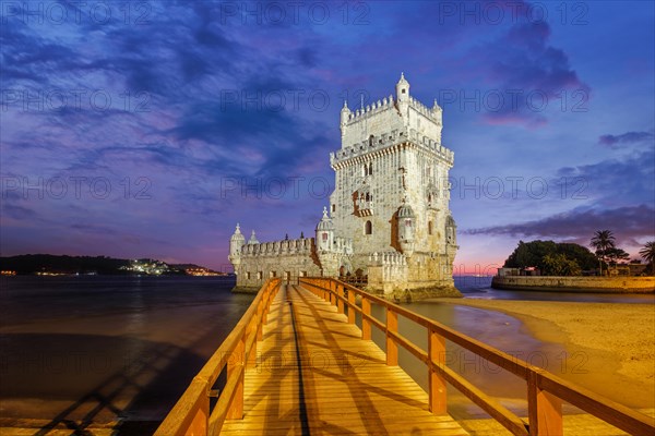 Belem Tower or Tower of St Vincent, famous tourist landmark of Lisboa and tourism attraction, on the bank of the Tagus River (Tejo) after sunset in dusk twilight with dramatic sky. Lisbon, Portugal, Europe