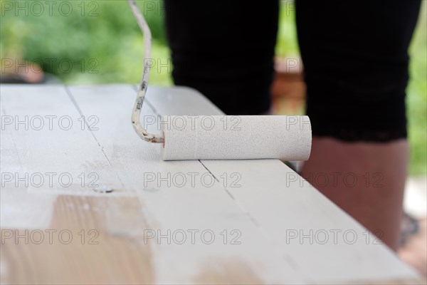 Paint roller, paint, wood, surface, craftsman, apply, restore, New white paint is applied to a wooden table with a paint roller