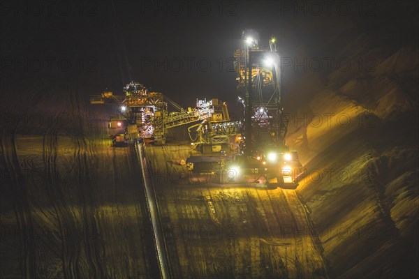 Mining machinery at night with intensive lighting during work, open-cast lignite mine, North Rhine-Westphalia, Germany, Europe