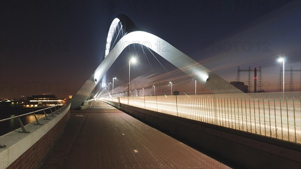 Night view of a modern bridge with futuristic architecture and symmetrical lighting, Nijmegen, Netherlands