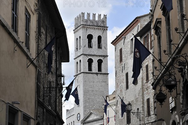 Old town alley decorated with flags, church tower of Santa Maria sopra Minerva church, city centre, old town, Assisi, Italy, Europe
