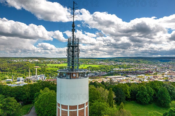 Radio tower rises above green landscape with city view and blue sky in the background, new water tower, Pforzheim, Germany, Europe