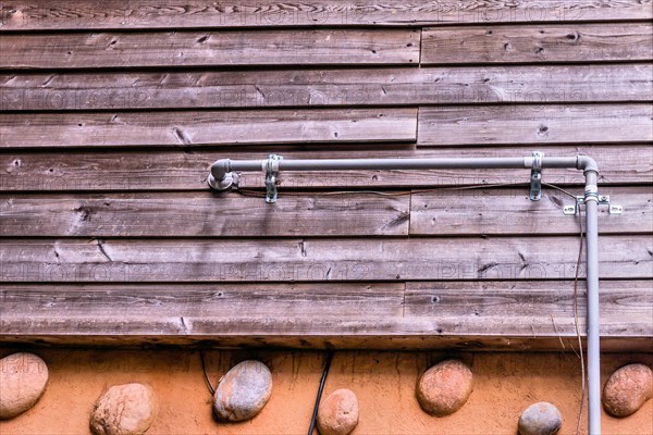 Metal gas line attached to exterior of building with wood siding