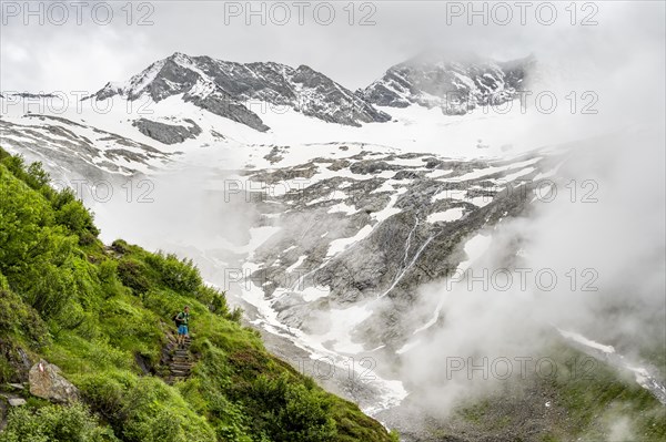 Mountaineers on a hiking trail, behind them cloudy summit Dosso Largo and glacier Schlegeiskees, ascent to Furtschaglhaus, Berliner Hoehenweg, Zillertal, Tyrol, Austria, Europe