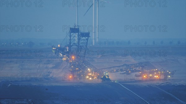 Illuminated bucket wheel excavator in an open-cast mine during the blue hour, open-cast lignite mine, North Rhine-Westphalia, Germany, Europe