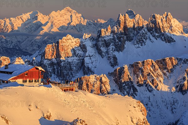 Mountain hut at sunset in the snow in front of rugged mountains, Rifugio Lagazuoi, Dolomites, Italy, Europe