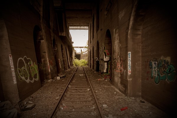 An abandoned railway tunnel with tracks lined with graffiti and rubbish, former Rethel railway branch, Lost Place, Flingern, Duesseldorf, North Rhine-Westphalia, Germany, Europe