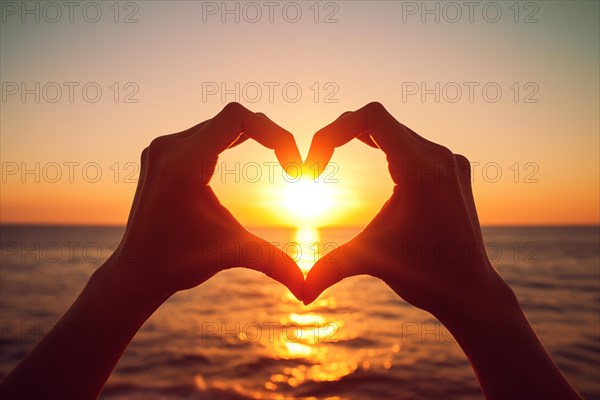 Two hands forming a heart shape, silhouetted against a breathtaking ocean sunset. Love and warmth on Valentine Day or any romantic occasion, AI generated