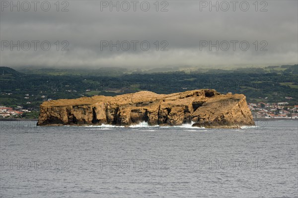The remote rocky island 'Iieu Deitado' off a coastline of Pico under a cloudy sky, Iieu Deitado, Iieu em Pe, Horta, Faial, Azores, Portugal, Europe