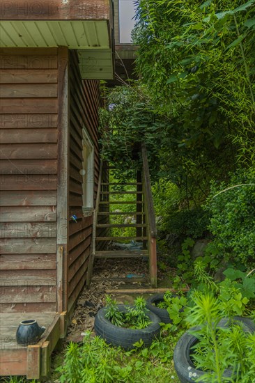 Daejeon, South Korea, June 29, 2018: Old tires laying in front of outside staircase attached to abandoned two story house, Asia