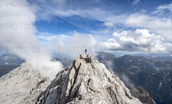 Mountaineer on the rocky summit of the Watzmann Mittelspitze, Watzmann crossing, view of mountain panorama, Berchtesgaden National Park, Berchtesgaden Alps, Bavaria, Germany, Europe