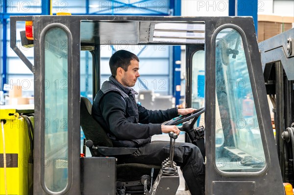 Man driving a forklift in a modern cnc logistic factory