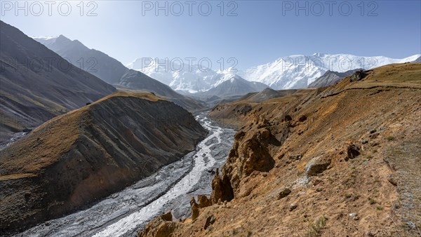 Achik Tash river, Achik Tash valley with rock formations, behind glaciated and snow-covered mountain peak Pik Lenin and Pik of the XIX Party Congress of the CPSU, Trans Alay Mountains, Pamir Mountains, Osh Province, Kyrgyzstan, Asia