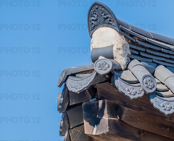 Corner of tiled roof of oriental building in a public park with intricate design details