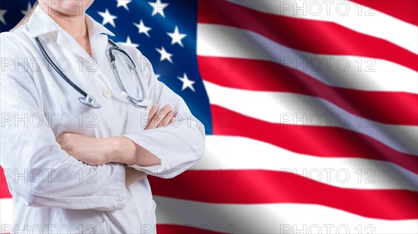Unrecognizable female doctor with arms crossed on American flag, Health and care with the flag of United State. Female doctor with stethoscope on American flag